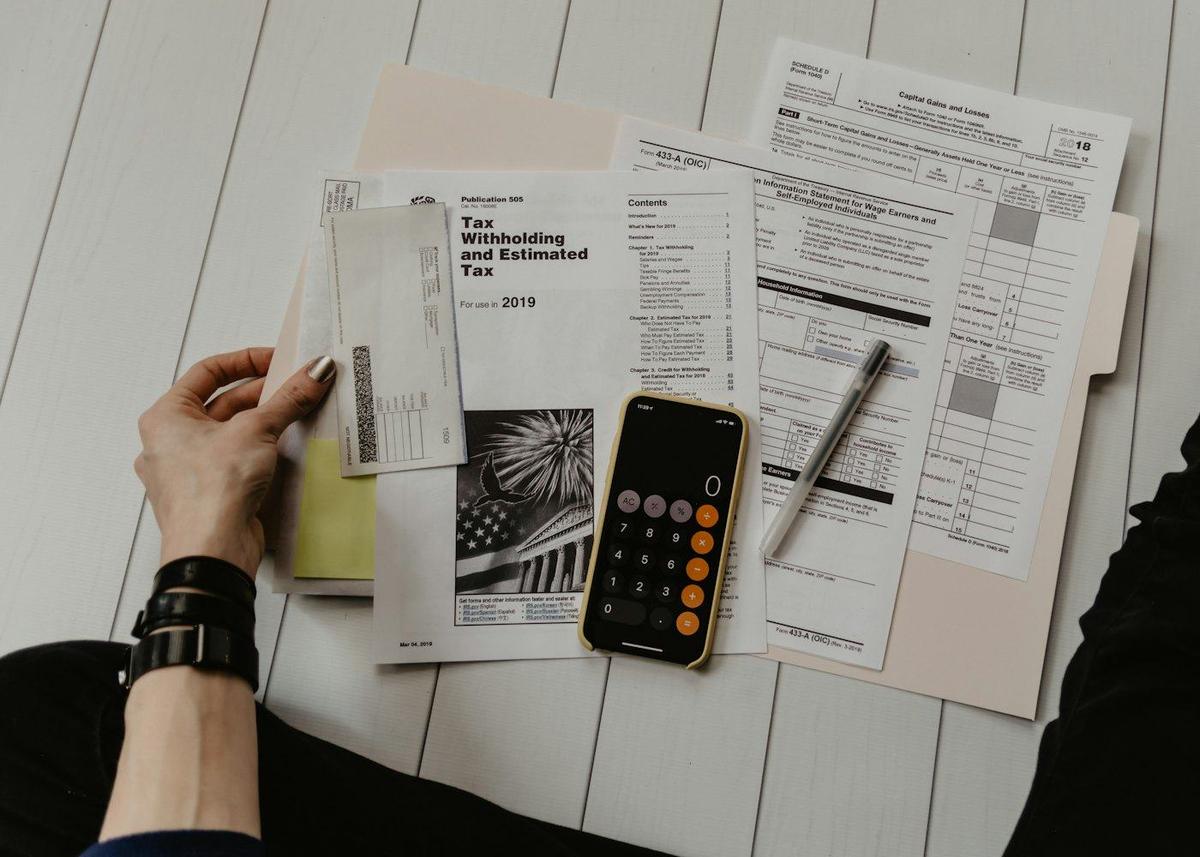Statements and a calculator spread across a table while sorting out debts