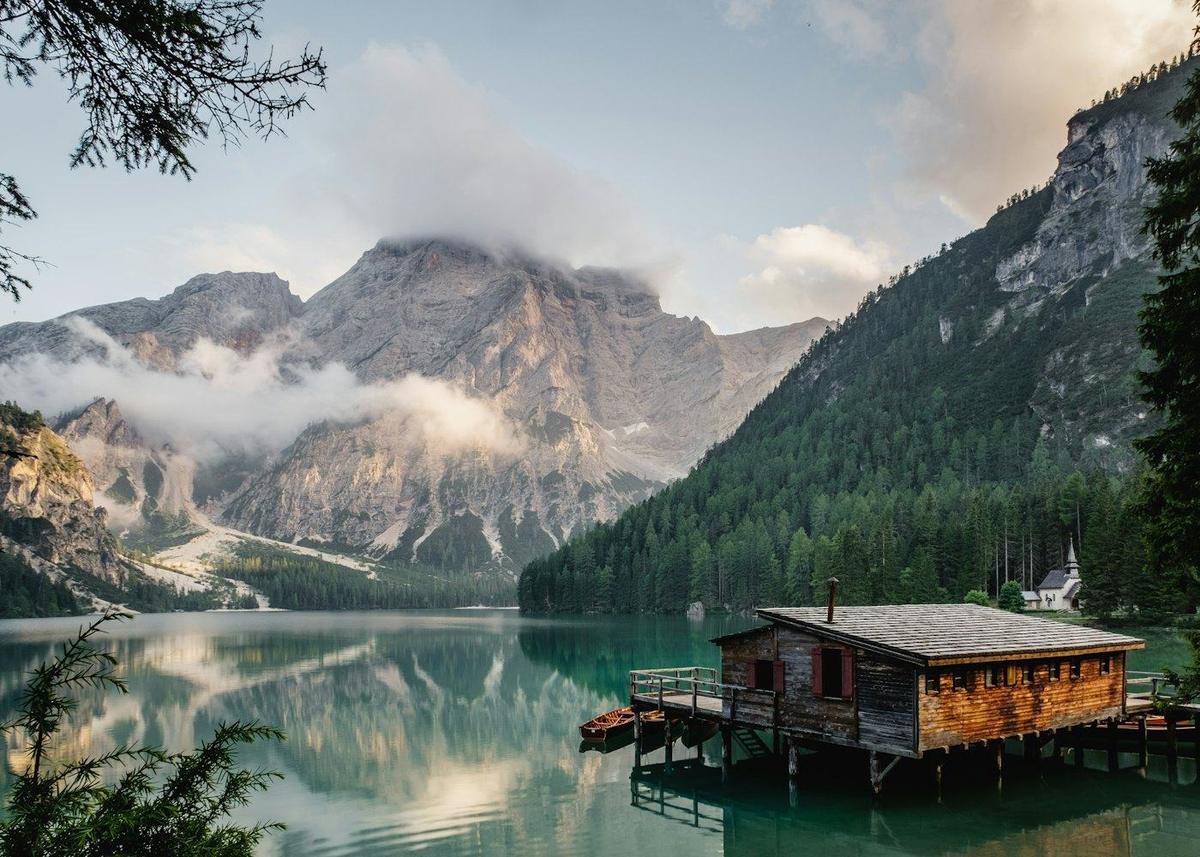A wooden cabin on a mountain lake